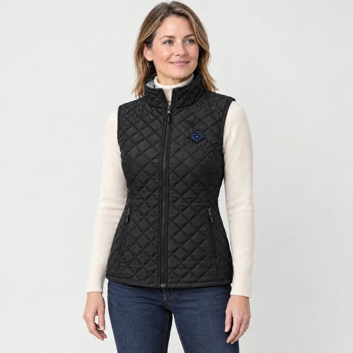 Woman wearing the black women's heated vest over a cream turtleneck